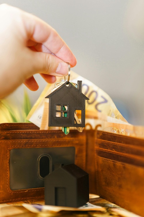 Huurverhoging gaat door foto van sleutelhanger met huis en geld